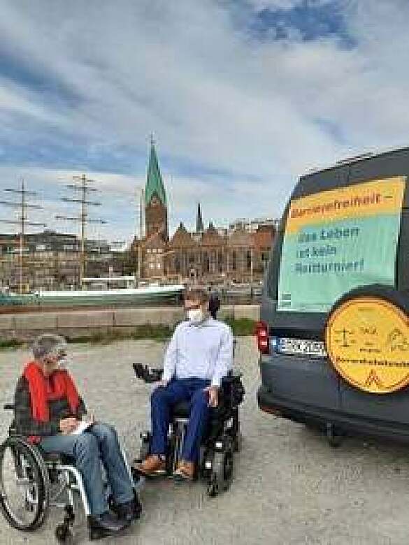 Sigrid Arnade im Gespräch mit Arne Frankenstein vor einem Auto