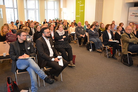 Auf dem Foto sieht man die Teilnehmerinnen und Teilnehmer der Fachveranstaltung. Sie sitzen nebeneinander in Stuhlreihen. 