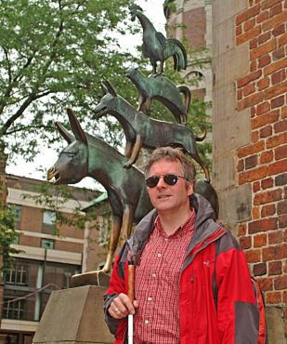 Joachim Steinbrück vor dem Bremer Stadtmusikanten. Das Foto wurde ca. 2009 aufgenommen. Joachim Steinbrück trägt ein rot kariertes Hemd.